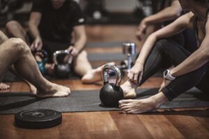 Group sitting on people with training weights in front of them