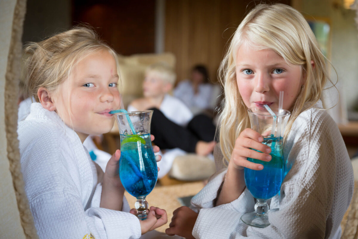 Barn på spa som dricker en blå drink