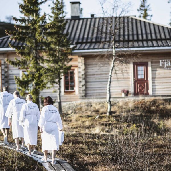 Visitors in dressing gowns walking towards Fjällvistet