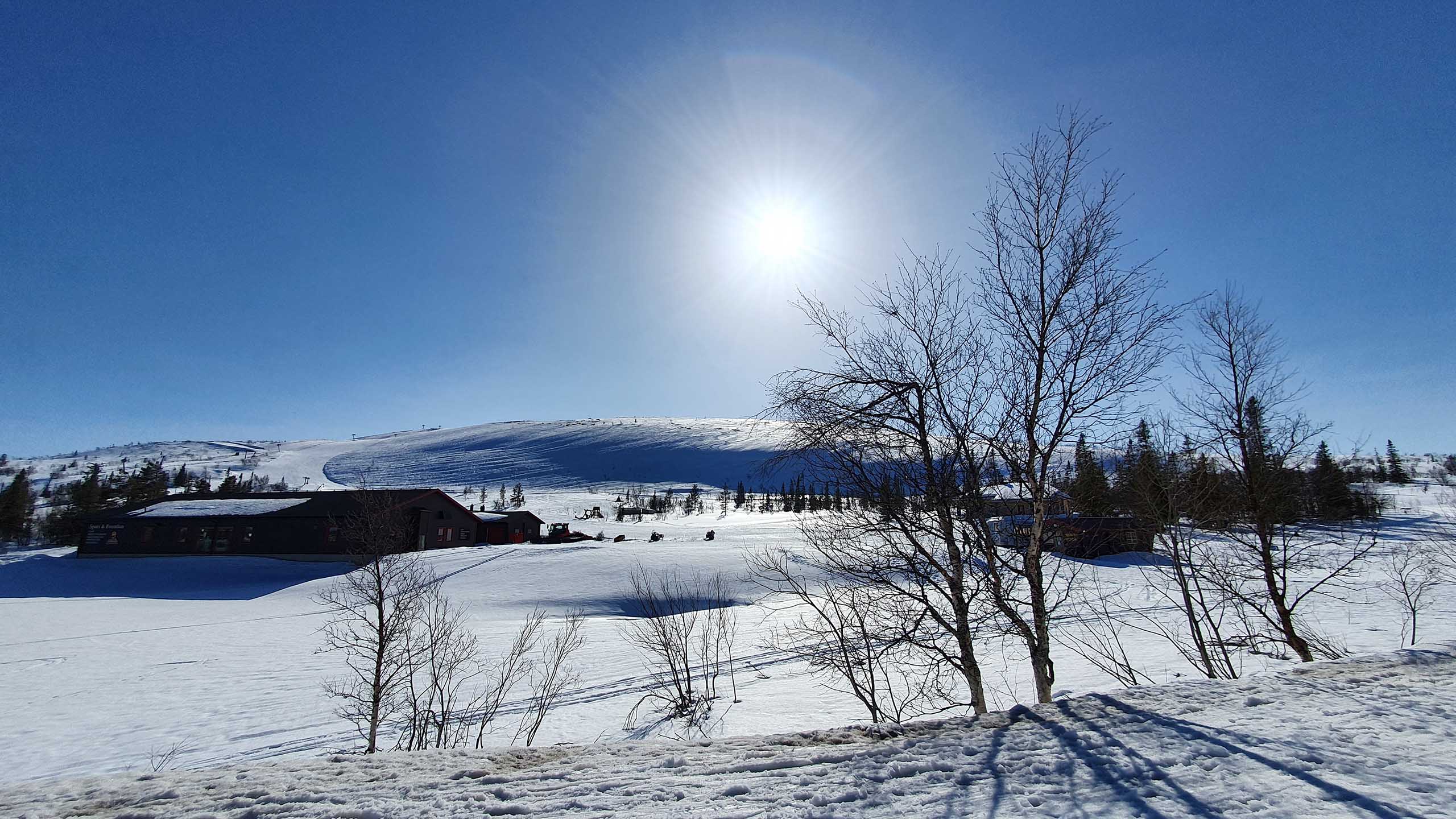 Vintervy över Storhogna Högfjällshotell & Spa med fjäll och blå himmel
