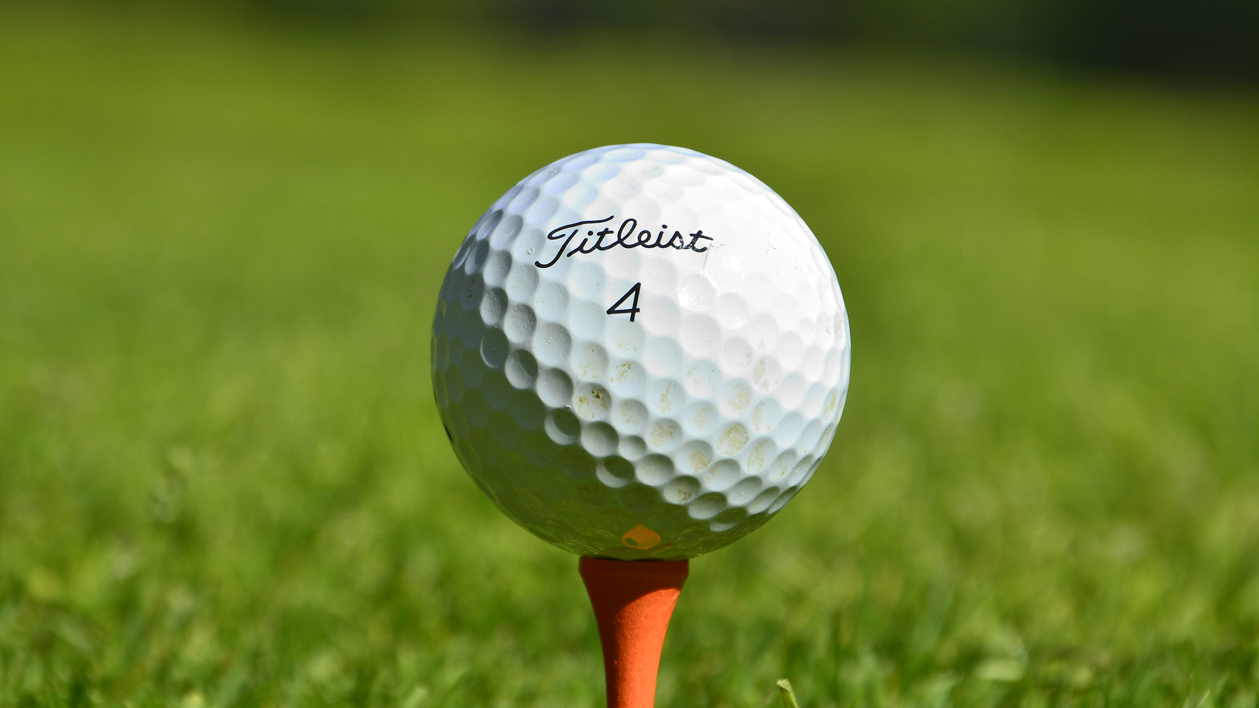 Golfboll Titleist 4 på orange golfpeg