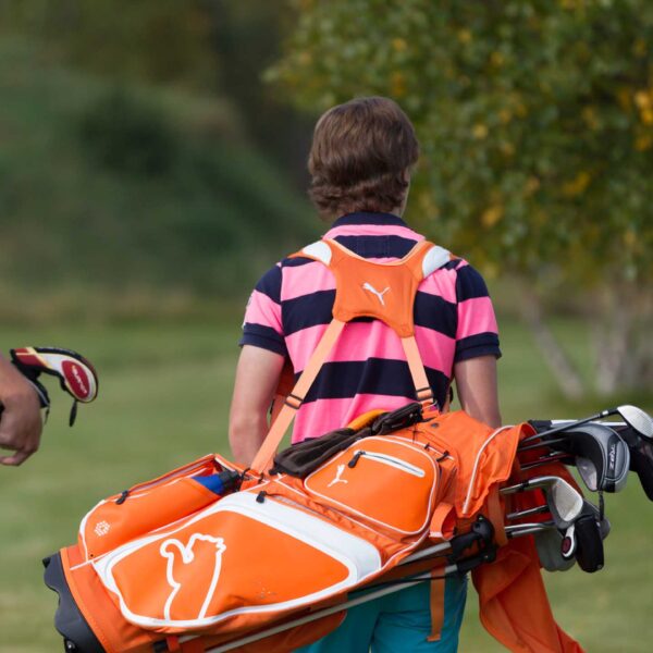 Golfspelare som bär sina golfbagar