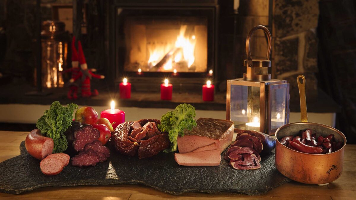 Närbild på del av julbord med kallskuret rökt kött, korv och leverpastej