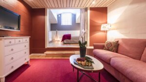 Sällskapsrum med soffa, byrå och TV i en Minisvit på Storhogna Högfjällshotell & Spa