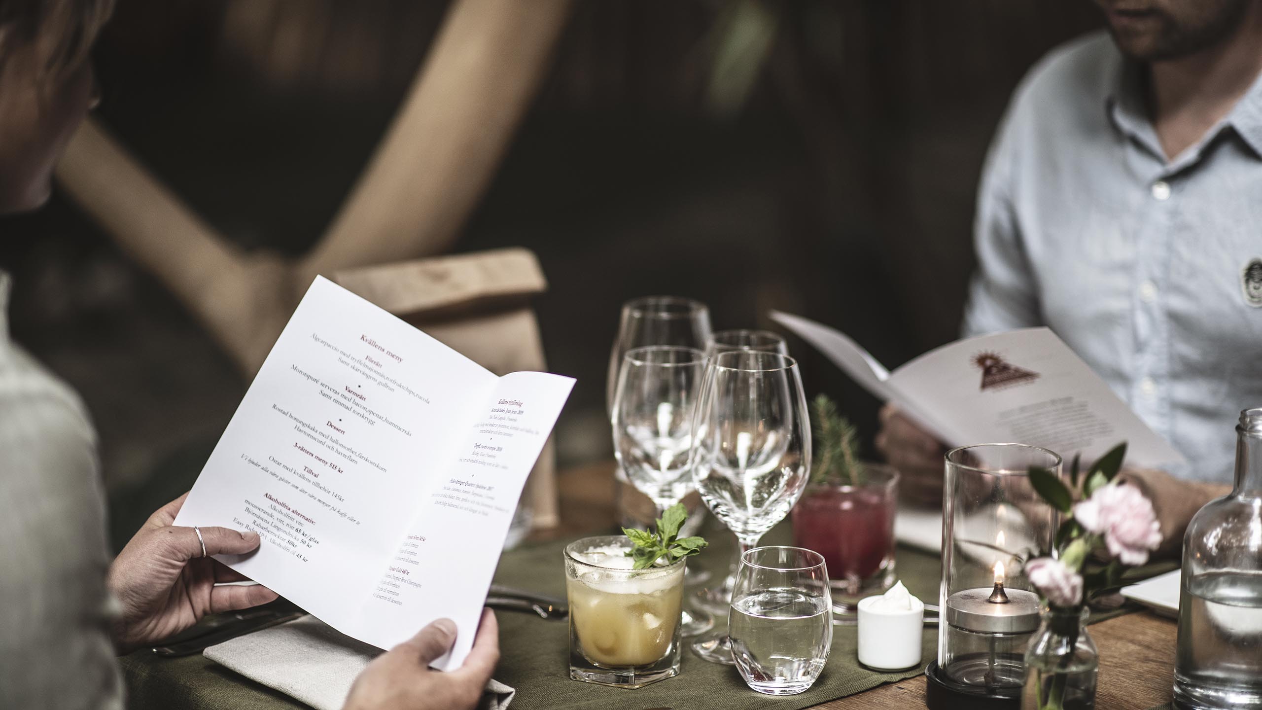 Restauranggäster sitter vid bordet och läser menyn