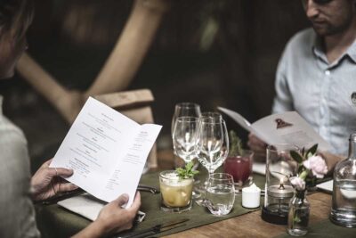 Restauranggäster sitter vid bordet och läser menyn