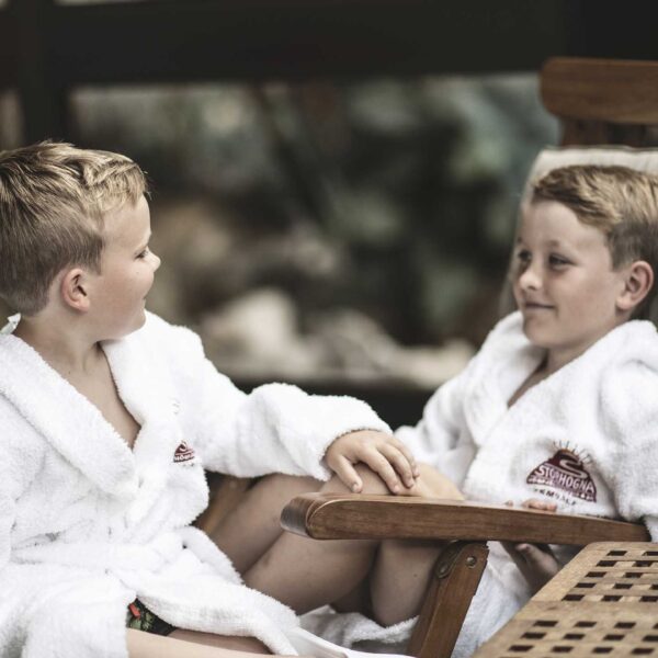 Två pojkar sitter och tar det lugnt i badrock på Storhogna Högfjällshotell & Spa