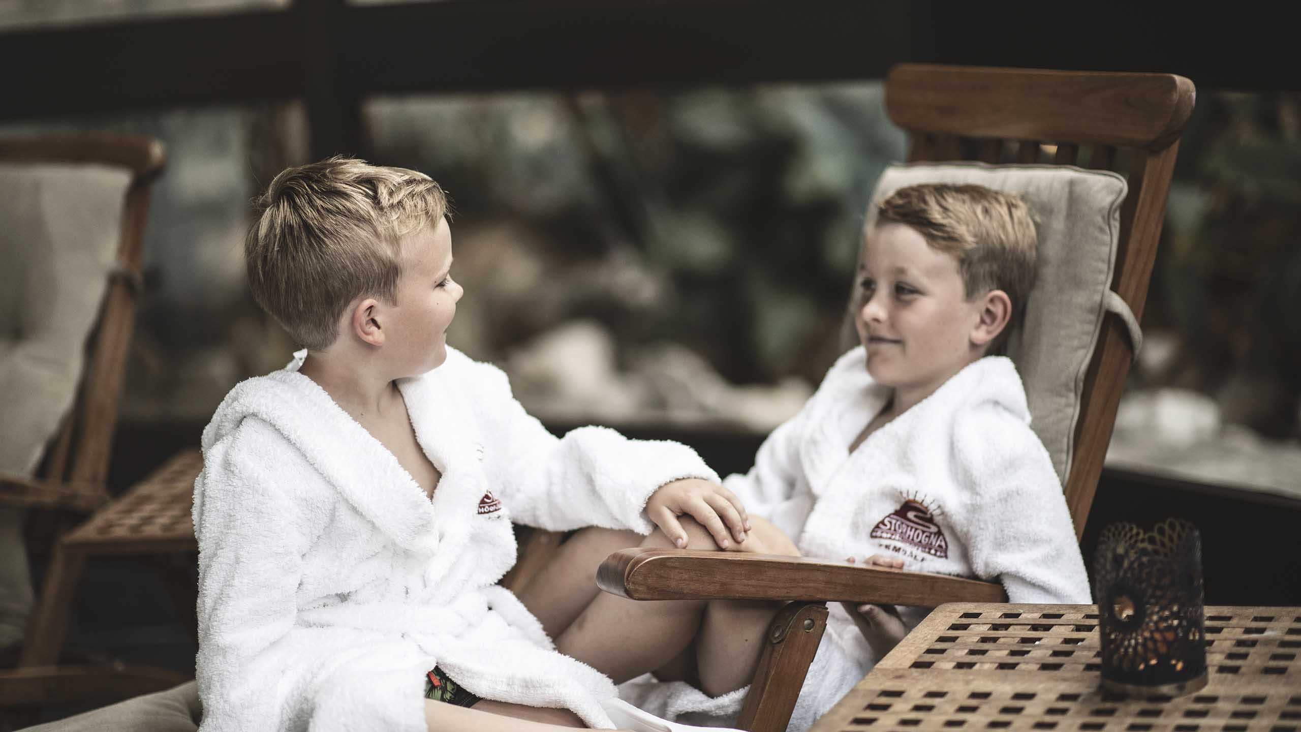 Två pojkar sitter och tar det lugnt i badrock på Storhogna Högfjällshotell & Spa